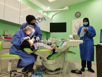 our-team-in-millennium-care-dental-clinic-attending-to-a-female-patient-lying-in-a-dental-chair.