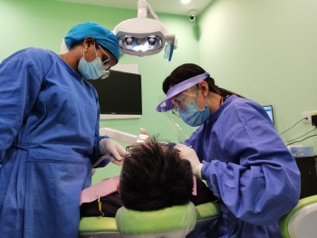 our-team-in-millennium-care-dental-clinic-attending-to-a-male-patient-lying-in-a-dental-chair.